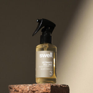 A bottle of Swell hair root complex on a stone background