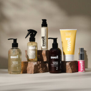 A pack shot of the full Swell haircare collection on a light stone background